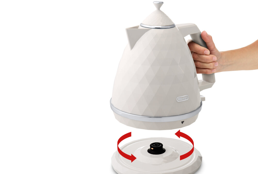 Biały czajnik o geometrycznym wzorze jest trzymany nad podstawą z czerwonymi strzałkami wskazującymi kierunek obrotu. Na czajniku widoczne jest logo \'DeLonghi\'.