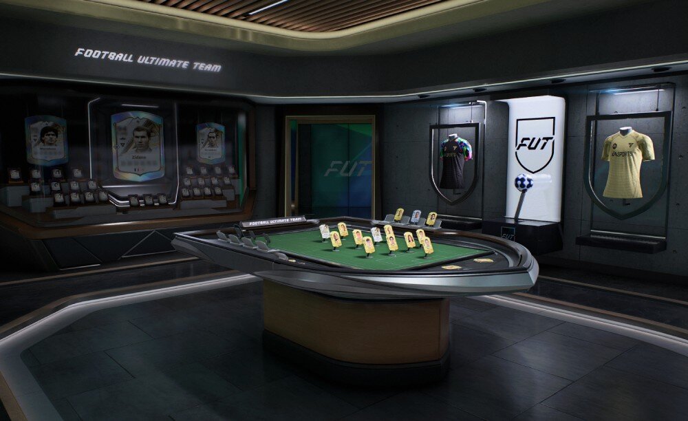 Pomieszczenie z futurystycznym stołem do gry, na którym znajdują się karty. Na ścianach widoczne są gabloty z koszulkami i napis \'FOOTBALL ULTIMATE TEAM\'.