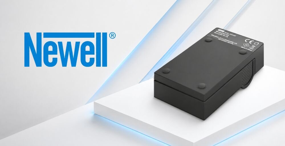 Na obrazie widoczna jest czarna ładowarka z napisem \'Newell\' oraz logo producenta. Ładowarka leży na białej powierzchni z niebieskimi akcentami świetlnymi.