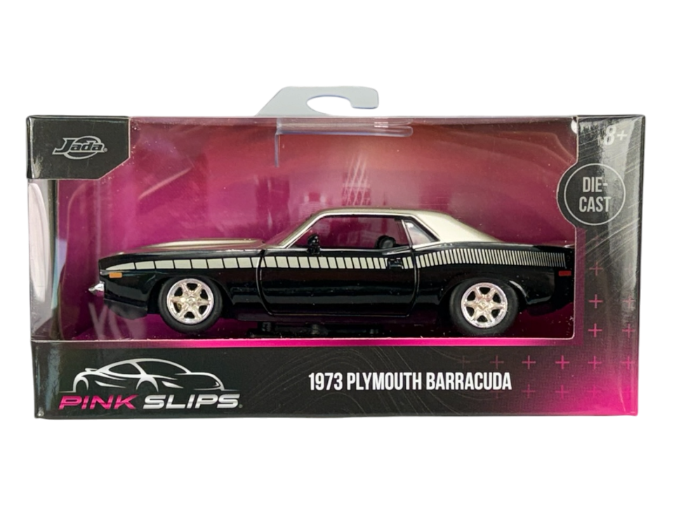 Model samochodu 1973 Plymouth Barracuda w kolorze czarno-złotym, zapakowany w pudełko z przezroczystym frontem. Na opakowaniu widoczne są napisy: \'Jada\', \'PINK SLIPS\', \'1973 PLYMOUTH BARRACUDA\' oraz \'DIE CAST\'.