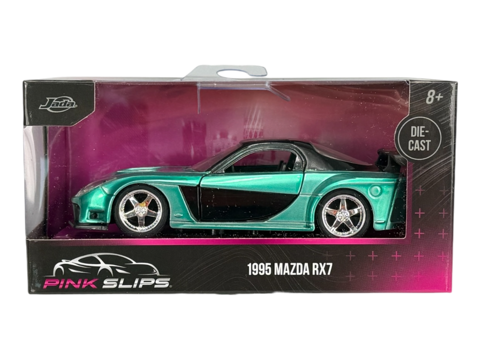 Model samochodu 1995 Mazda RX7 w kolorze zielonym, umieszczony w przezroczystym opakowaniu z napisem \'PINK SLIPS\' i \'1995 MAZDA RX7\'. Widoczne logo \'Jada\' oraz oznaczenie \'DIE-CAST\'.