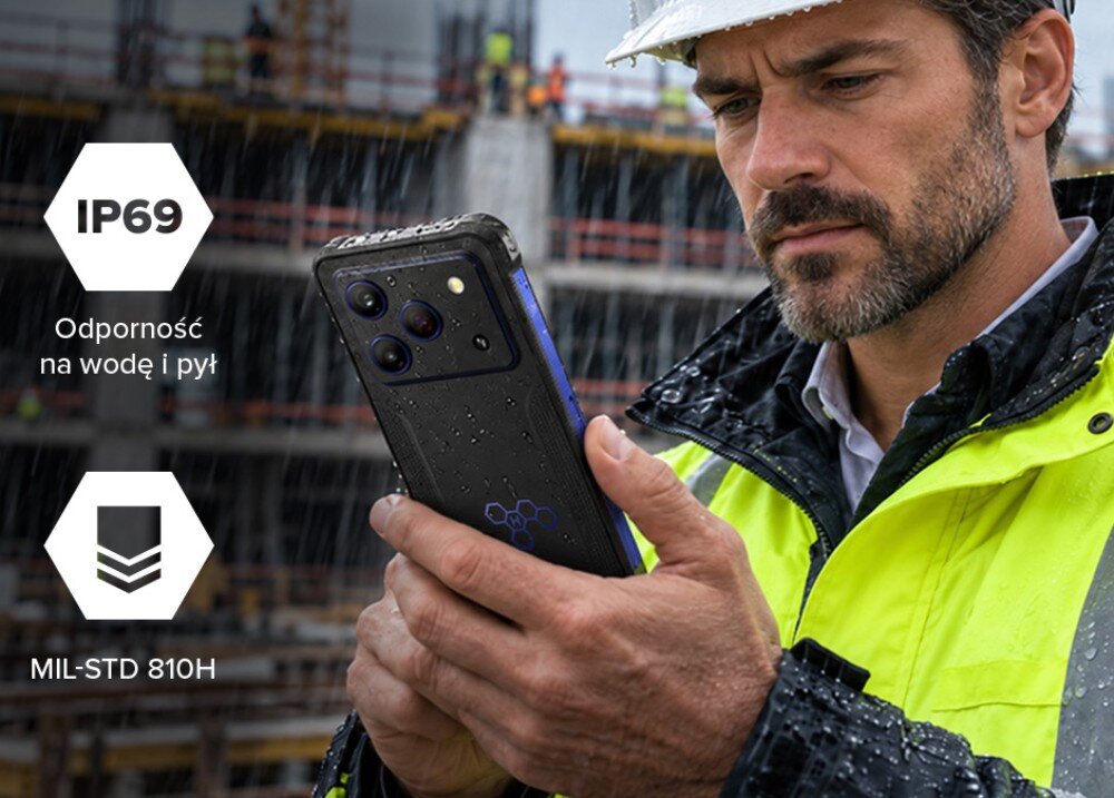 Smartfon HAMMER Blade 6 Pro 5G Mężczyzna w kasku i kamizelce na placu budowy trzyma mokry smartfon w deszczu, obok widoczne ikony IP69 oraz MIL-STD 810H