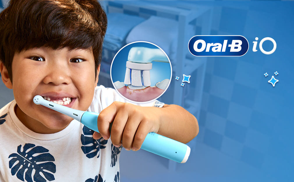 Dziecko trzyma niebieską szczoteczkę do zębów Oral-B iO. Obok widoczne jest logo Oral-B iO oraz ilustracja przedstawiająca szczoteczkę czyszczącą zęby.