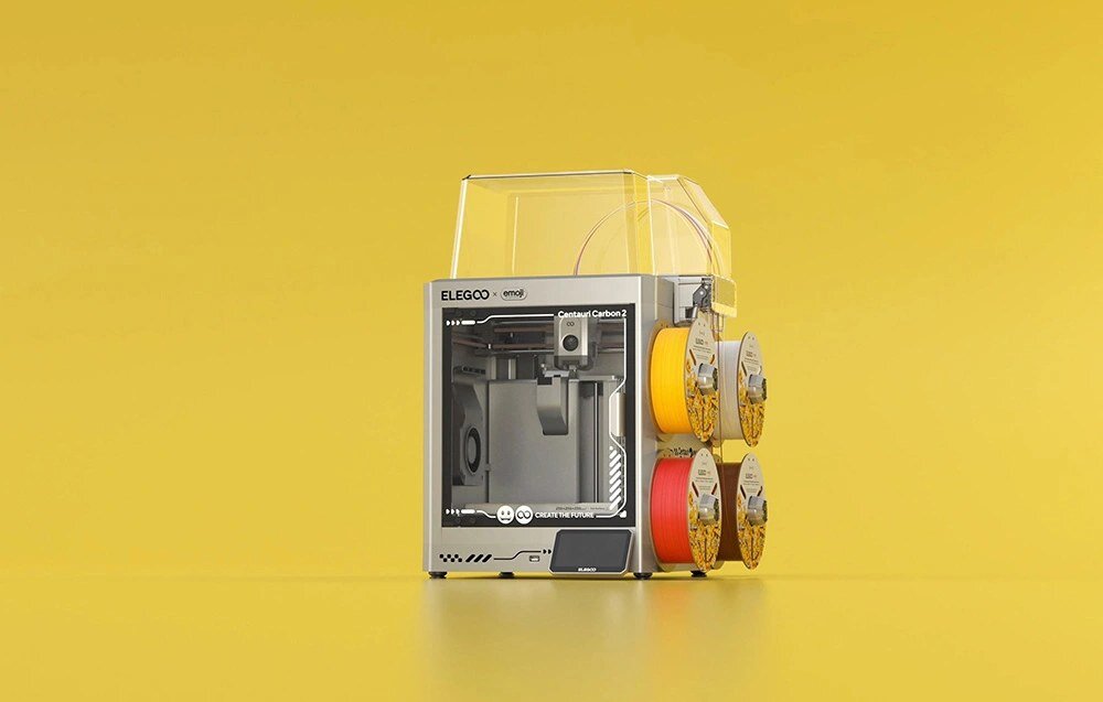 Drukarka 3D ELEGOO x emoji Centauri Carbon 2 Combo na żółtym tle.