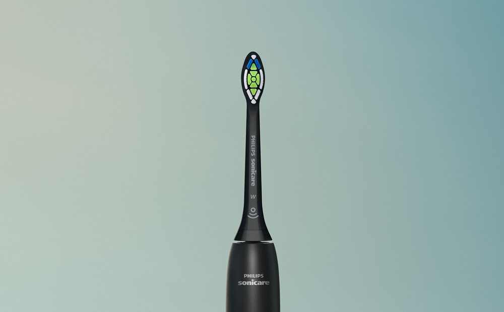 Czarna szczoteczka soniczna z kolorowymi włóknami na końcówce, na tle gradientu od jasnego do ciemnego niebieskiego. Widoczne logo \'PHILIPS Sonicare\' na uchwycie.