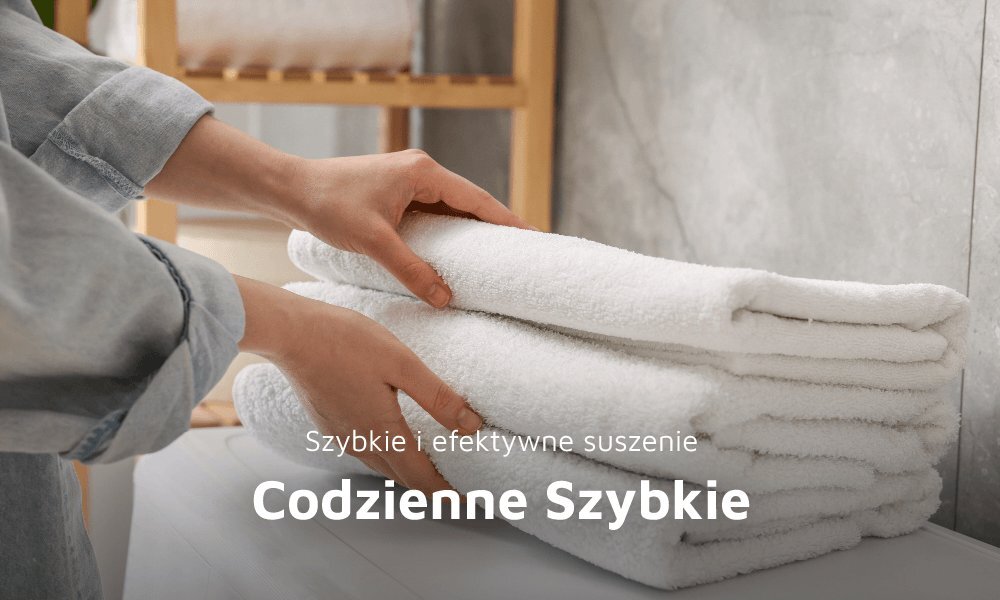 Osoba układa stos białych ręczników na blacie. Na obrazie widoczny jest tekst: \'Szybkie i efektywne suszenie Codzienne Szybkie\'.