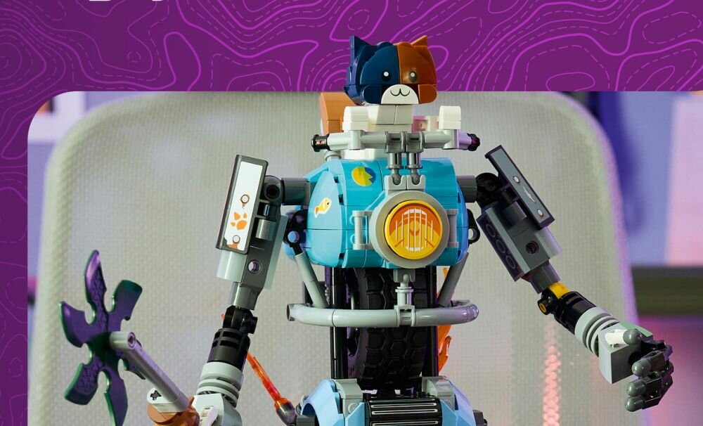 Zestaw LEGO przedstawiający robota z elementami w kolorach niebieskim, czarnym i pomarańczowym, z głową przypominającą kota. W tle widoczny jest fioletowy wzór.
