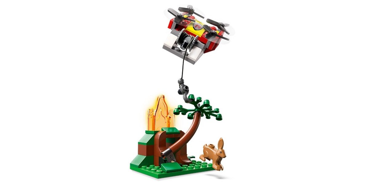Zestaw LEGO przedstawia drona z kamerą unoszącego się nad drzewem i płomieniem, obok którego stoi figurka królika. Elementy są kolorowe, z dominacją zieleni, brązu i czerwieni.