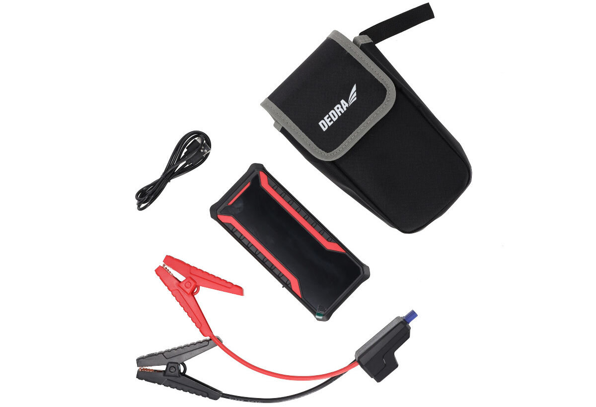 Na obrazie widoczny jest czarny powerbank z czerwonymi akcentami, czarny pokrowiec z napisem \'DEDRA\', kabel oraz czerwono-czarne kable rozruchowe.