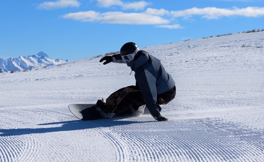 Smartfon VIVO X500 Pro 5G Snowboardzista jadący po przygotowanym stoku w słoneczny dzień z widokiem na góry