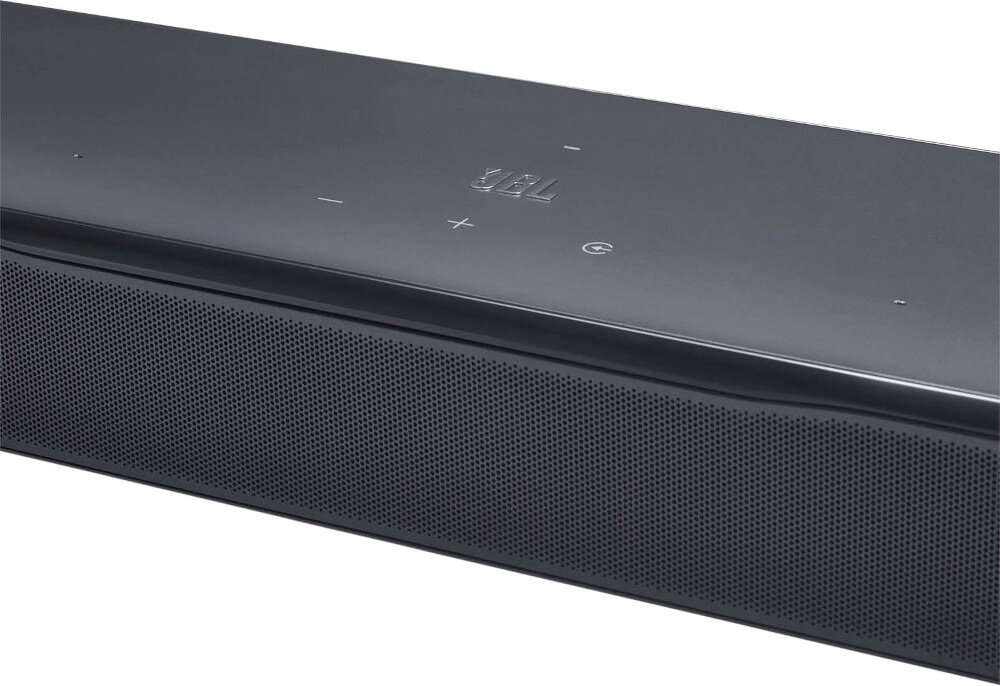 Czarny soundbar z widocznym logo \'JBL\' na górnej powierzchni oraz przyciskami dotykowymi oznaczonymi symbolami. Przednia część urządzenia ma perforowaną powierzchnię.