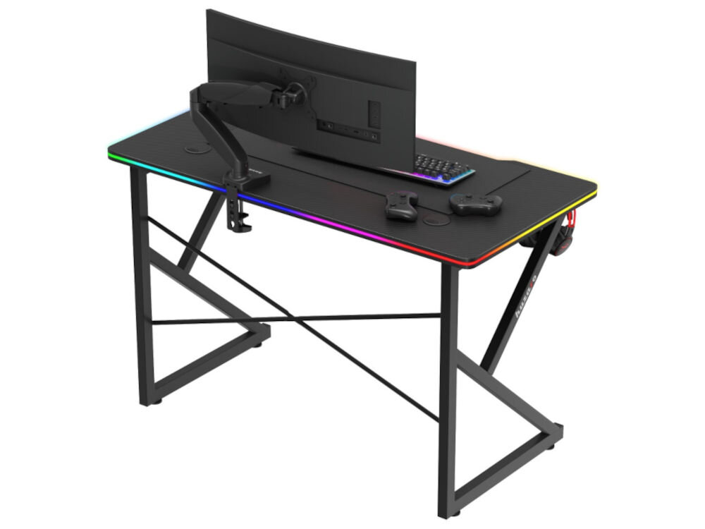 Czarne biurko gamingowe z podświetleniem RGB na krawędziach, wyposażone w monitor, klawiaturę i dwa kontrolery. Konstrukcja biurka jest metalowa z krzyżowymi wspornikami.