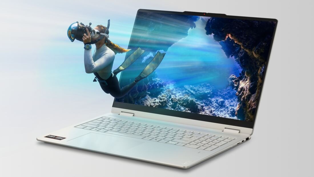 Laptop z otwartym ekranem, na którym wyświetlany jest obraz nurka pod wodą w jaskini. Klawiatura jest jasna, a obudowa ma srebrny kolor.