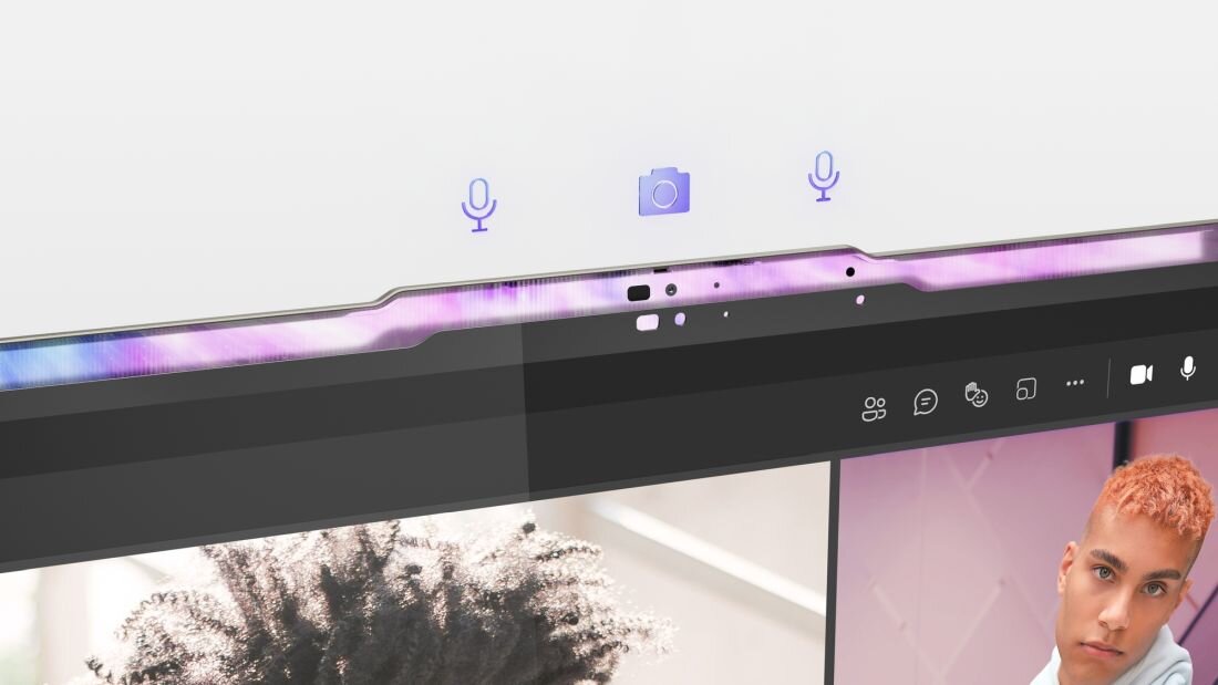 Obraz przedstawia górną część ekranu laptopa z widocznymi ikonami mikrofonu i kamery. Na ekranie widać fragmenty dwóch osób podczas wideorozmowy.