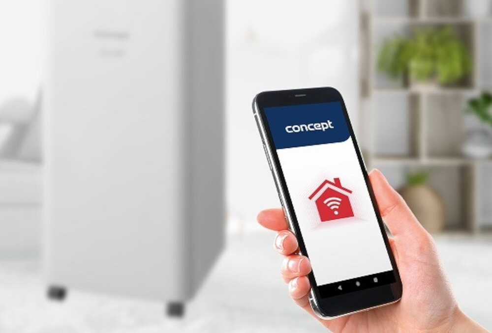 Osoba trzyma smartfon z aplikacją, na której widnieje logo \'concept\' oraz ikona domu z sygnałem Wi-Fi. W tle widoczny jest biały osuszacz powietrza na kółkach.