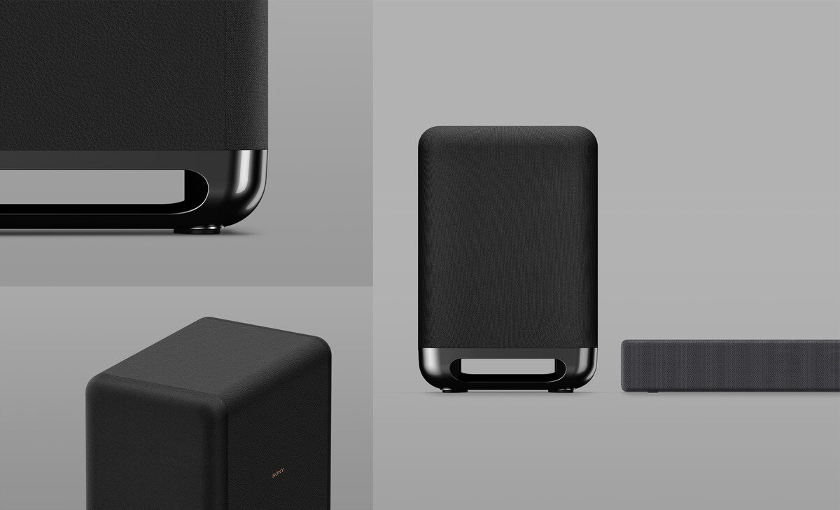 Obraz przedstawia czarny subwoofer o prostokątnym kształcie z zaokrąglonymi krawędziami i metaliczną podstawą. Obok subwoofera widoczny jest fragment soundbara.