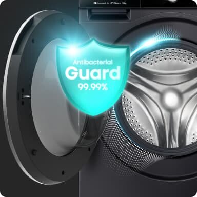 Obraz przedstawia otwarte drzwiczki pralki z widocznym bębnem. Na drzwiczkach znajduje się grafika z napisem \'Antibacterial Guard 99.99%\'.