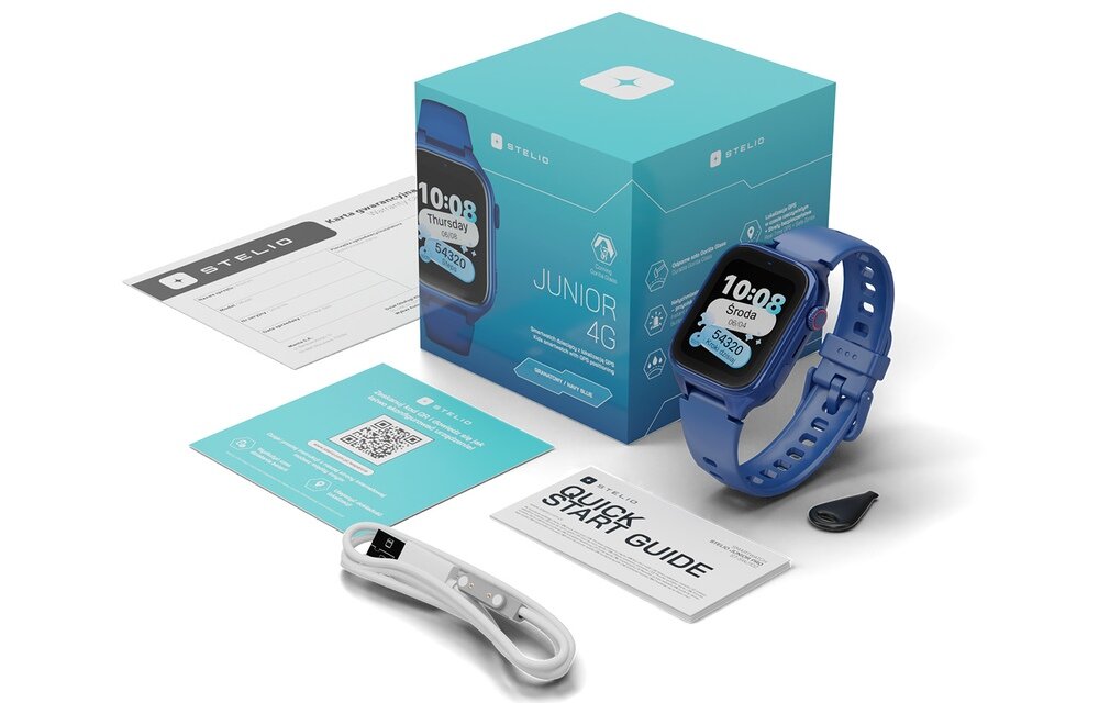 Na obrazie znajduje się smartwatch w kolorze granatowym z wyświetlaczem pokazującym godzinę 10:08 i dzień \'Środa\'. Obok zegarka widoczne są pudełko z napisem \'JUNIOR 4G\', przewód do ładowania, instrukcja \'QUICK START GUIDE\' oraz karta z kodem QR.