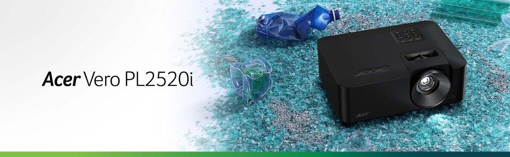 Obraz przedstawia czarny projektor z widocznym obiektywem, umieszczony na tle z pokruszonego szkła i plastikowych butelek. Po lewej stronie widnieje napis \'Acer Vero PL2520i\'.