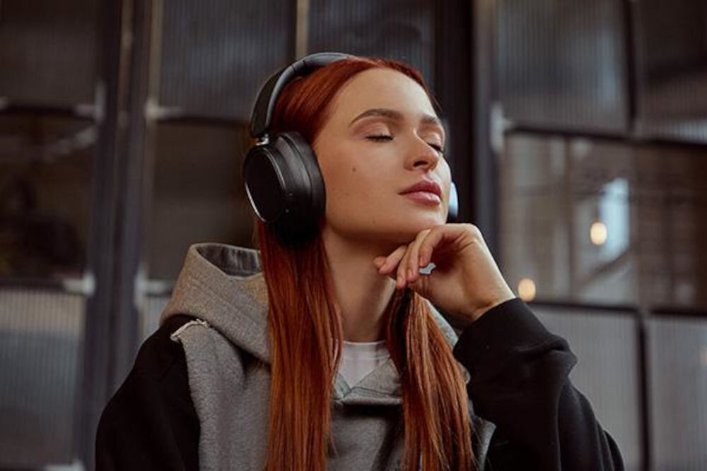 EDIFIER ES850NB ANC słuchawki bezprzewodowe hybrydowa redukcja hałasu Ambient Sound tryby ANC, osoba z założonymi słuchawkami nausznymi wsłuchana w muzykę