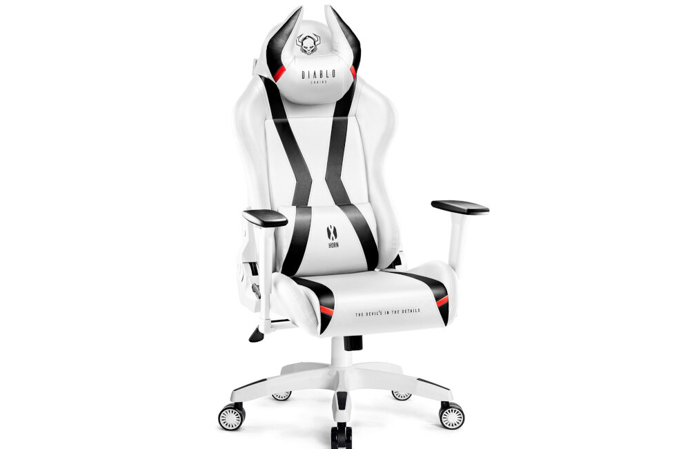 Biało-czarny fotel gamingowy z logo \'DIABLO CHAIRS\' na zagłówku i napisem \'THE DEVIL IS IN THE DETAILS\' na siedzisku. Fotel posiada regulowane podłokietniki i kółka u podstawy.
