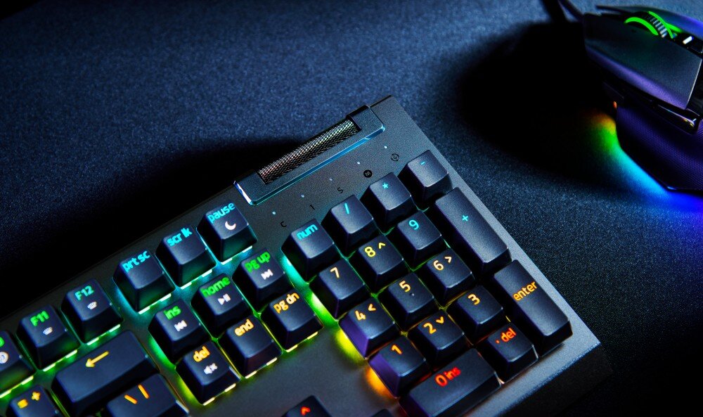 Klawiatura z podświetleniem RGB, widoczne klawisze funkcyjne i numeryczne. Obok znajduje się myszka z podświetleniem.