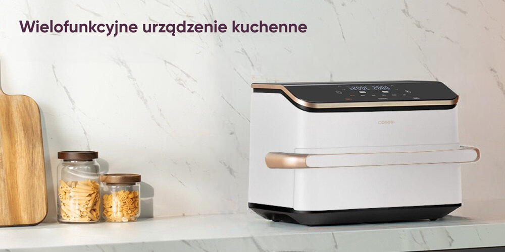 Na blacie kuchennym stoi biała frytkownica beztłuszczowa z czarnym panelem sterowania i złotymi akcentami. Obok znajdują się dwa słoiki z przekąskami i drewniana deska do krojenia, a na ścianie widnieje napis \'Wielofunkcyjne urządzenie kuchenne\'.