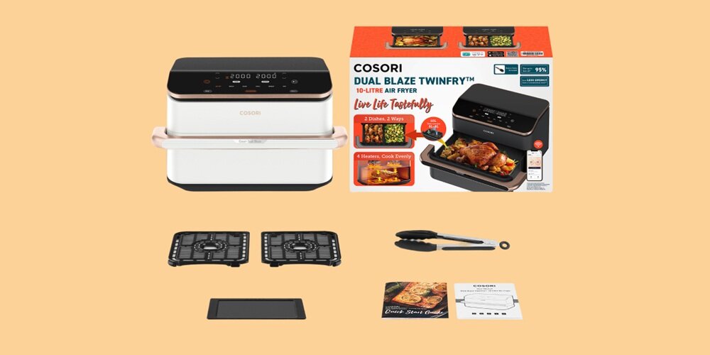 Na obrazie znajduje się frytkownica beztłuszczowa COSORI z panelem dotykowym, obok której leży pudełko z napisem \'COSORI DUAL BLAZE TWINFRY 10-LITRE AIR FRYER\'. W zestawie znajdują się również dwa ruszty, szczypce, instrukcja oraz książka z przepisami.