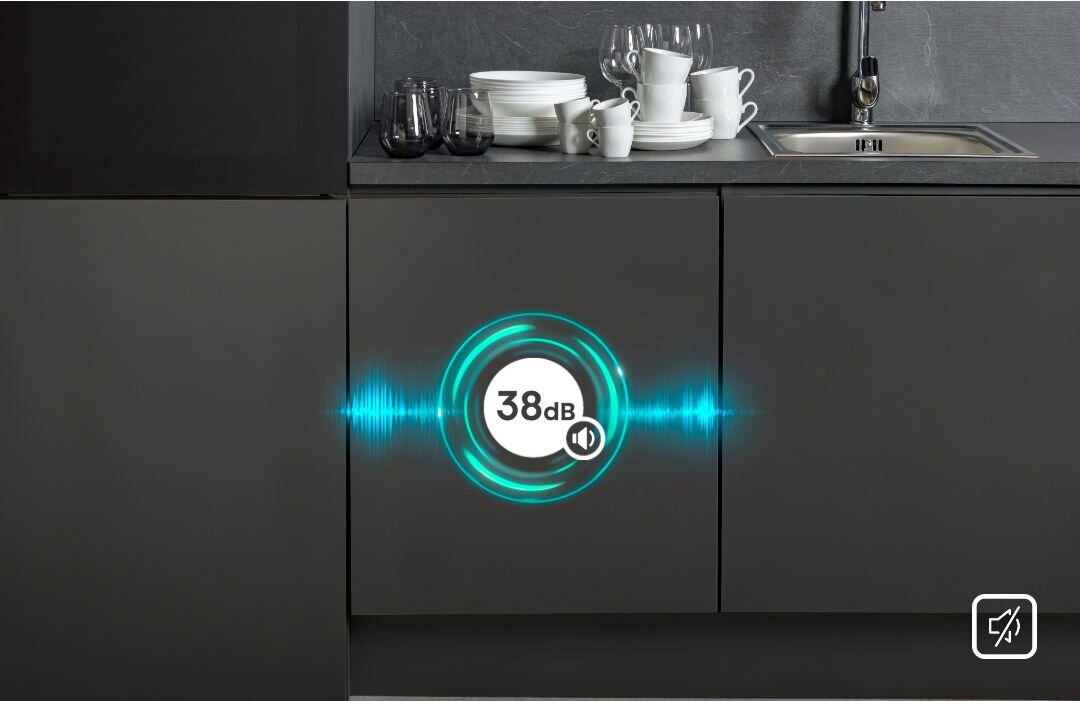 Kuchnia z ciemnymi szafkami, na blacie stoją białe naczynia i szklanki. Na drzwiach zmywarki widoczny jest symbol z napisem \'38 dB\'.