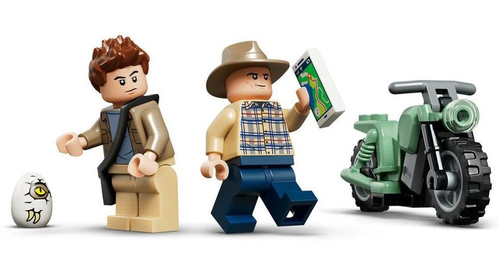Na obrazie znajdują się dwie figurki LEGO, jedna trzyma telefon z mapą, obok nich stoi motocykl i jajko z okiem. Figurka po lewej ma brązowe włosy i kurtkę, a figurka po prawej nosi kapelusz i koszulę w kratę.