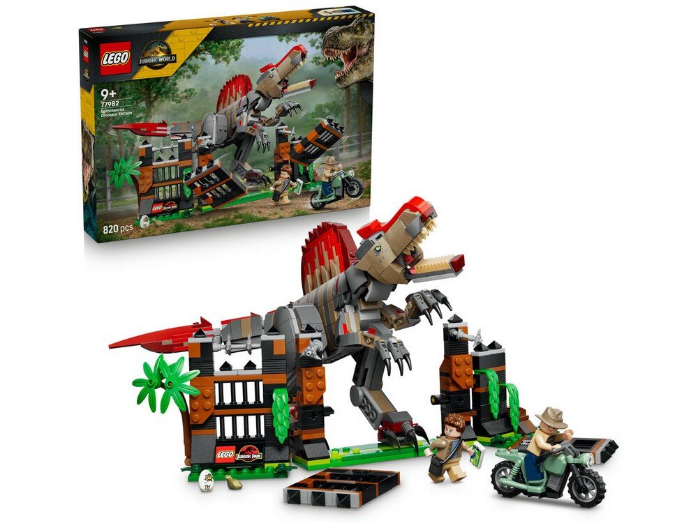 Zestaw LEGO przedstawia scenę z dinozaurem i dwoma postaciami, w tym jedną na motocyklu, otoczonymi elementami przypominającymi bramę i roślinność. W tle widoczne jest pudełko z grafiką zestawu i logo LEGO Jurassic World.