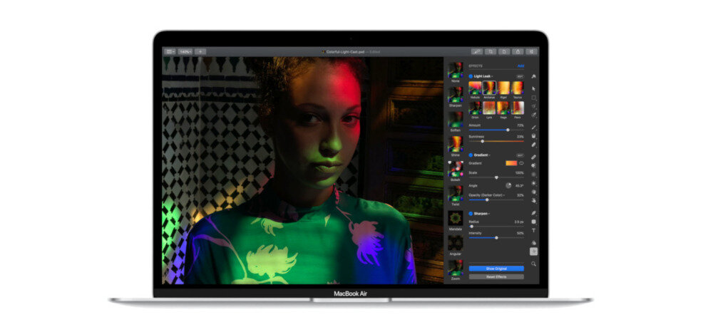 Laptop z otwartym ekranem, na którym widoczna jest edytowana fotografia przedstawiająca osobę w kolorowych światłach. Na dolnej ramce ekranu znajduje się napis \'MacBook Air\'.