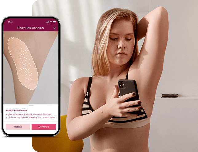 Osoba w stroju kąpielowym trzyma smartfon, a na ekranie widać aplikację \'Body Hair Analyzer\' z zaznaczonym obszarem na skórze. W tle znajduje się jasne wnętrze z meblami.