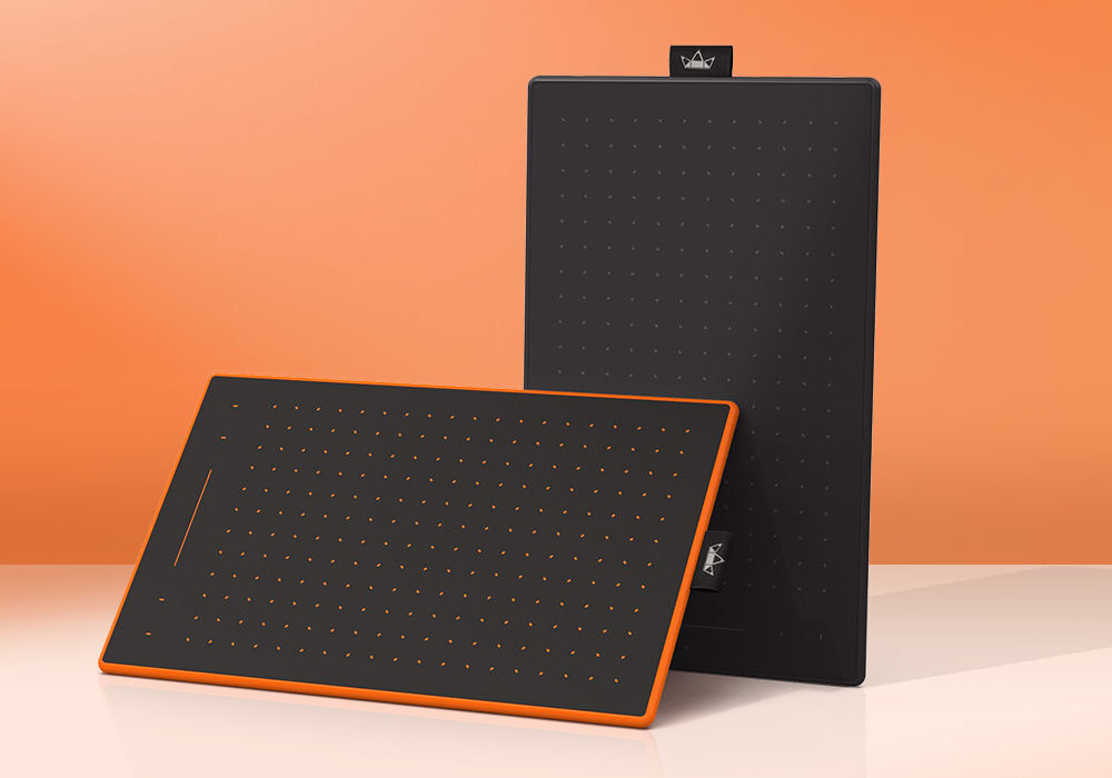 Na obrazie widoczne są dwa czarne tablety graficzne z pomarańczowymi krawędziami, ustawione na tle w kolorze pomarańczowym. Na obu tabletach znajdują się drobne, regularnie rozmieszczone punkty oraz logo producenta.