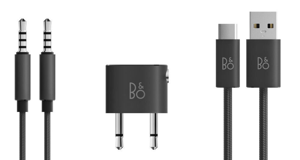Na obrazie widoczne są czarne kable audio z wtykami jack oraz adapter z logo \'B&O\'. Obok znajduje się kabel USB z końcówkami USB-C i USB-A, również z logo \'B&O\'.