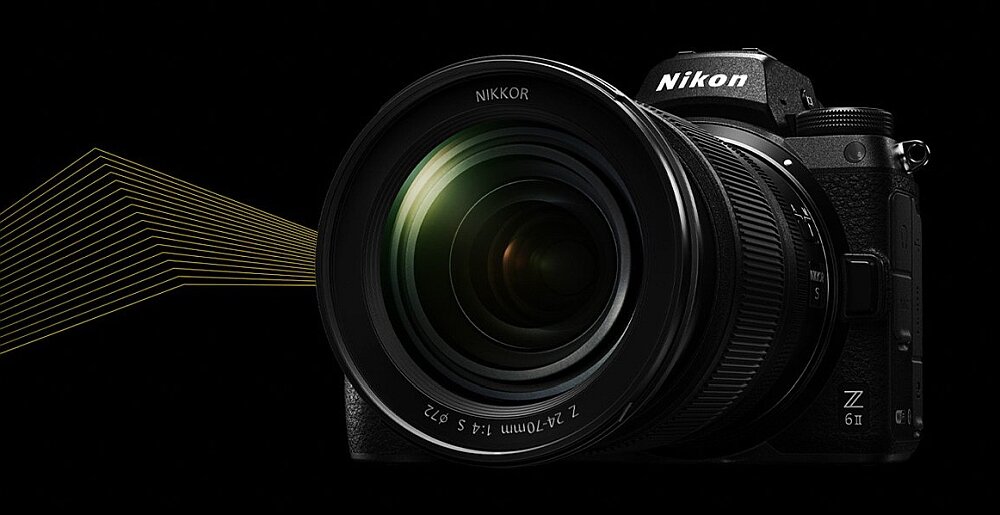 Aparat bezlusterkowy z dużym obiektywem, na którym widoczny jest napis \'NIKKOR Z 24-200mm f/4-6.3\'. Na korpusie aparatu znajduje się logo \'Nikon Z 6II\'.