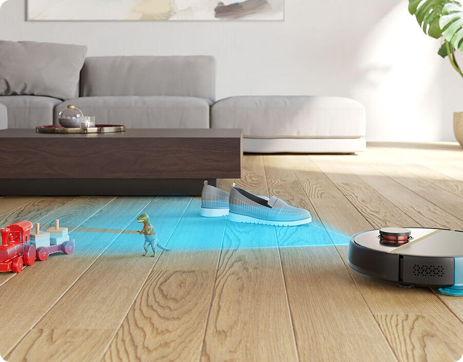 Robot sprzątający porusza się po drewnianej podłodze, omijając zabawki i buty dzięki niebieskiemu światłu skanującemu. W tle znajduje się szara sofa i niski stolik z dekoracją.