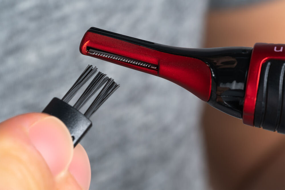 Trymer GÖTZE & JENSEN TR500 Czyszczenie czerwono-czarnego trymera Götze & Jensen za pomocą dołączonej małej szczoteczki z czarnym włosiem.