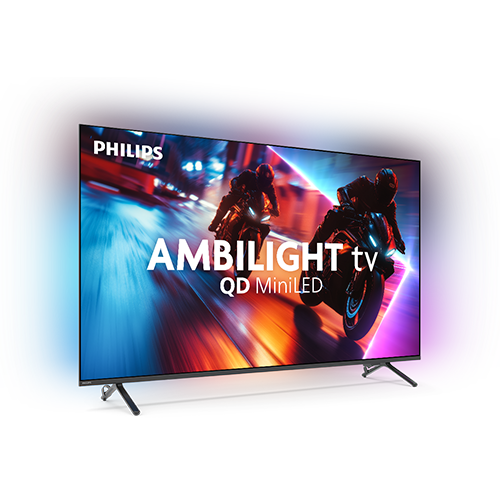 Telewizor z logo PHILIPS wyświetla dynamiczną scenę z motocyklistami. Na ekranie widoczny jest tekst: \'AMBILIGHT tv QD MiniLED\'.