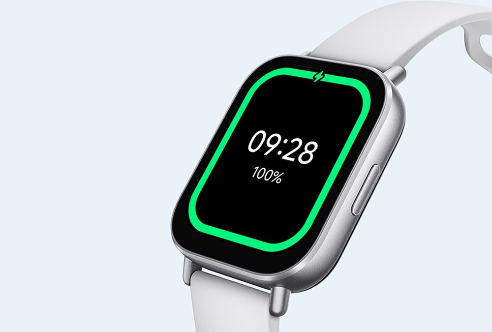 Smartwatch z prostokątnym ekranem, na którym wyświetlany jest czas 09:28 i poziom naładowania 100%. Pasek zegarka jest jasny, a obudowa ma metaliczny kolor.