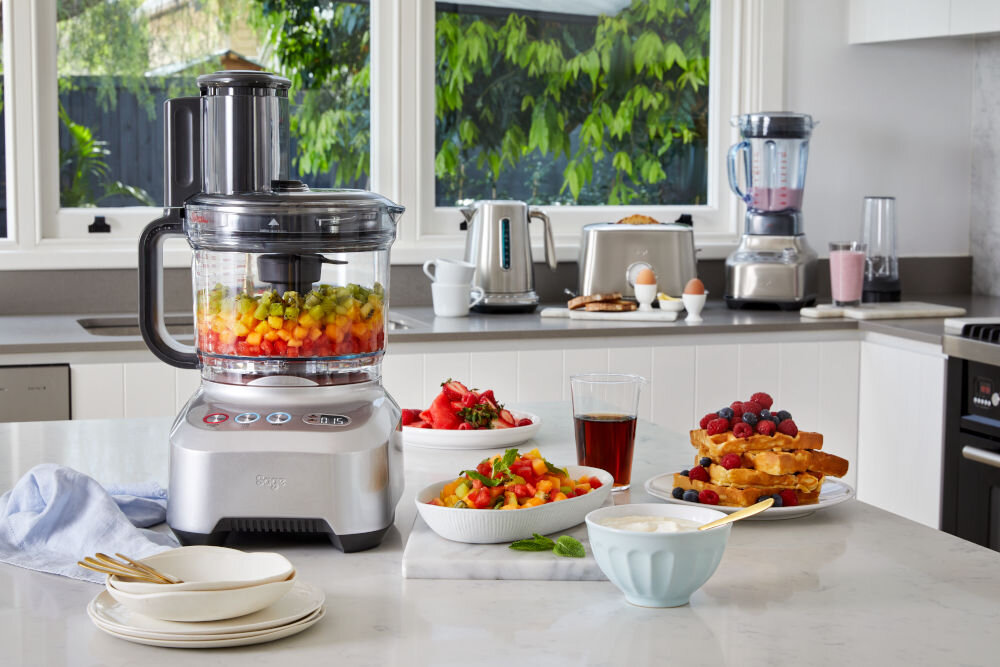 Blender kielichowy SAGE SBL820 jeden blender stoi na stole a drugi na blacie srebrne obudowy w jednym różowy napój w kielichu w drugim pokrojone składniki system noży wykonanych ze stali nierdzewnej precyzja efektywność cięcia Specjalnie zaprojektowany kształt noży rozdrabnianie twardych składników na drobne cząsteczki optymalnie gładka konsystencja funkcjonalność wygoda użytkowania 