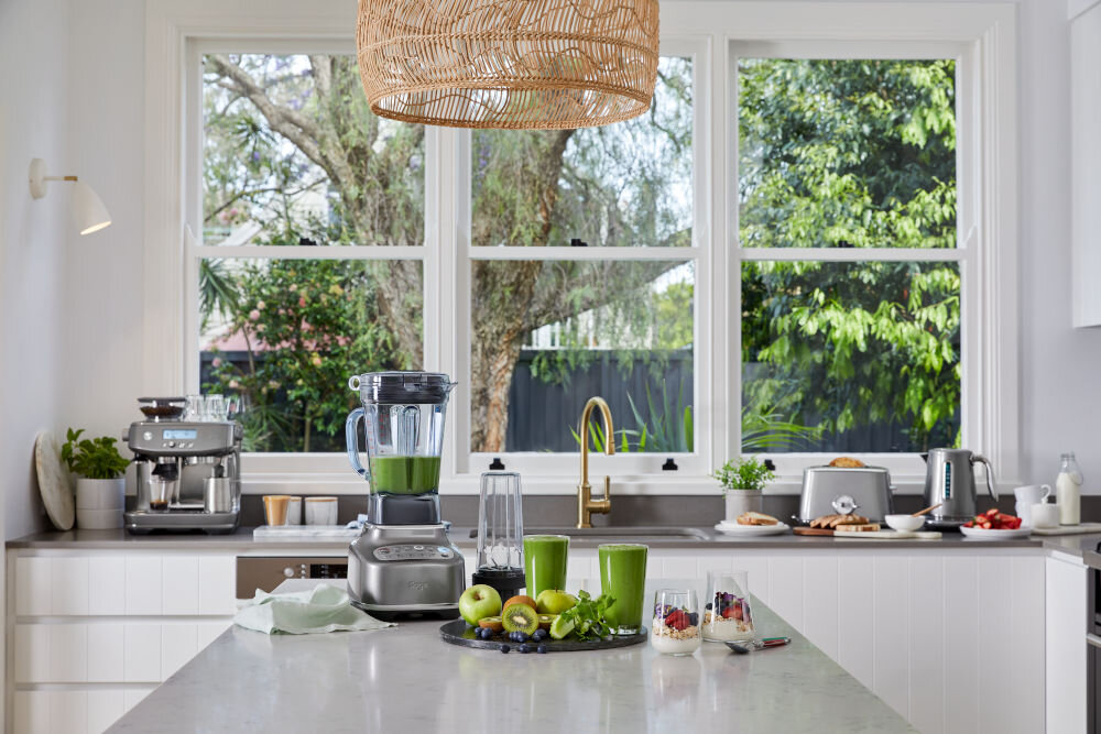 Blender kielichowy SAGE SBL820 blender stoi na blacie srebrna obudowa przyciski zielony napój wewnątrz kielicha imponująca moc wyrafinowany wygląd kompaktowe wymiary (46 x 21 x 27 cm) stylowy design precyzyjne wykonanie solidna konstrukcja intensywne wyzwania kulinarne elegancja praktyczność 