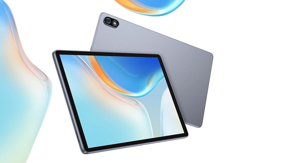 Obraz przedstawia szary tablet z dużym ekranem, na którym widoczna jest abstrakcyjna grafika w odcieniach niebieskiego i pomarańczowego. W tle widać tylną część tabletu z kamerą w rogu.