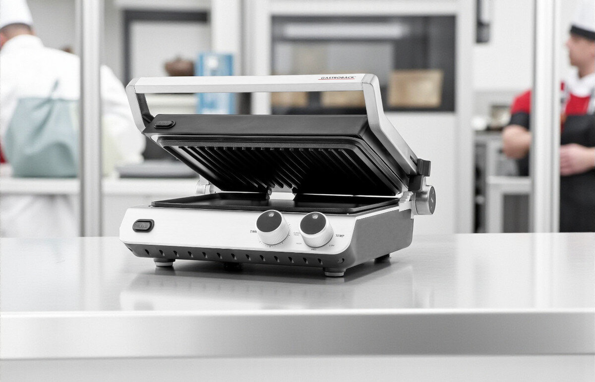 Grill elektryczny GASTROBACK 42537, gotowanie, smażenie, grillowanie, kuchnia, grill stoi na blacie metalowym na zapleczu w kuchni