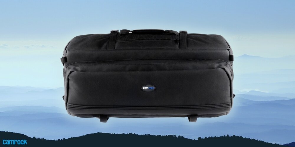 Czarna torba fotograficzna Camrock Tank X65 na tle gór i błękitnego nieba, widok z przodu, logo Camrock na środku.