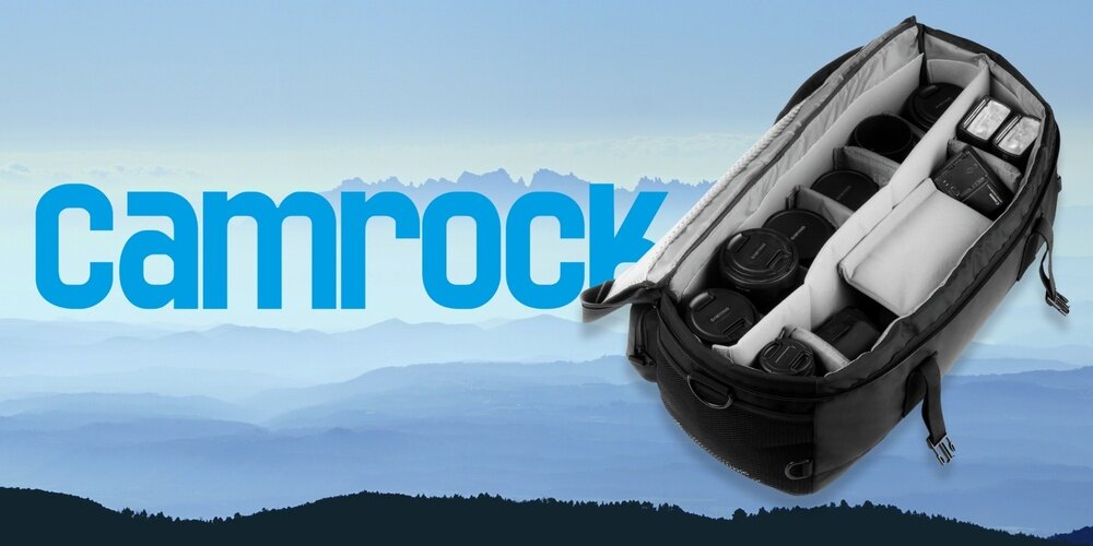 Torba Camrock Tank X65 otwarta, z uporządkowanym sprzętem fotograficznym w przegrodach, na tle gór i logo Camrock.