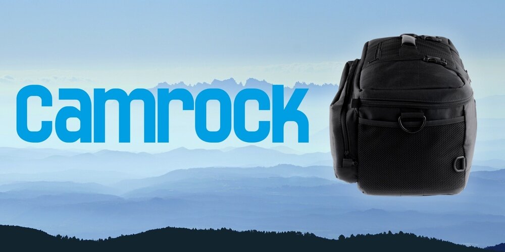 Czarna torba Camrock Tank X65 widoczna od boku z kieszenią siatkową, ustawiona na tle gór i dużego logo Camrock.