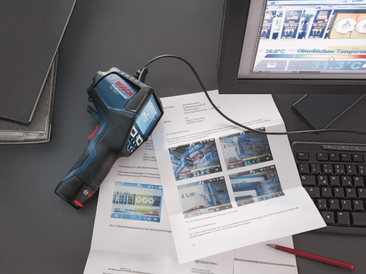 Termodetektor BOSCH Professional GIS 1000 C 0601083301, zakres, stopnie, wyświetlacz, diagnoza, Termodetektor leży na stole biurowym, w tle dokumentacja i laptop