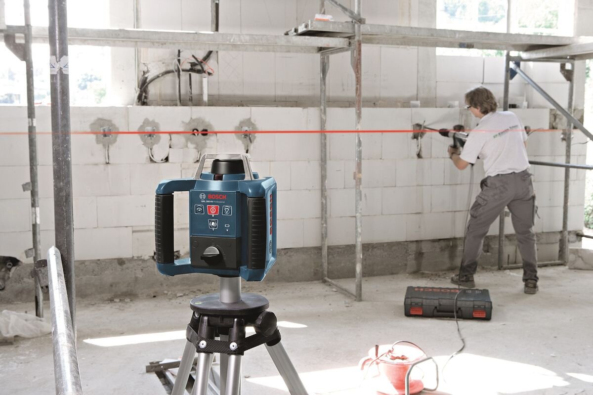 Laser obrotowy BOSCH Professional GRL 300 HV 0601061501, precyzja, laser, wiązka, niwelacja, Laser Bosch GRL 300 HV na statywie podczas prac instalacyjnych wewnątrz.