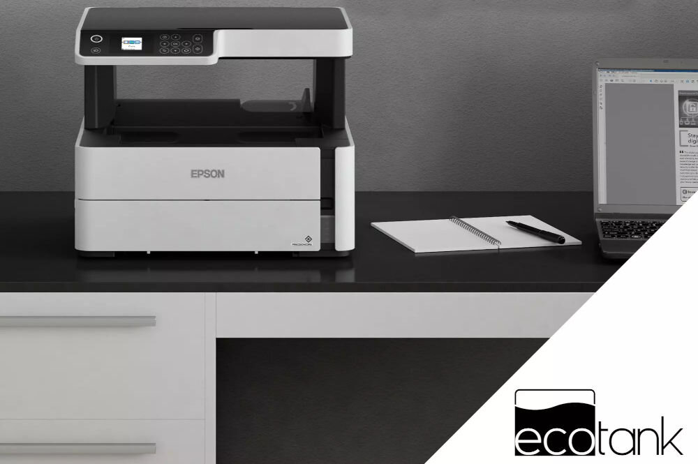 Urządzenie wielofunkcyjne EPSON EcoTank M2170 Automatyczny druk dwustronny, Wi-Fi prezentacja urządzenia na biurku obok notes i laptop ciemna ściana bezkartridżowa oszczędność kosztów
